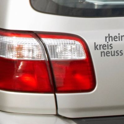 Ein Autoaufkleber mit dem Schriftzug "rhein kreis neuss"  in der Farbe anthrazit)