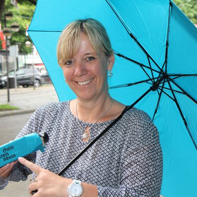 Eine Frau mit einem Regenschirm in der Farbe Türkis