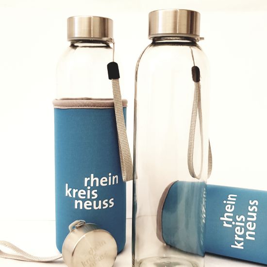 Glasflasche mit Schraubverschluss, Trageriemen sowie blau-weißem Neopren-Überzug und „Rhein-Kreis Neuss“-Schriftzug.